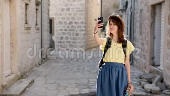 年轻的时髦旅行者女孩在城里散步通过智能手机自拍在欧洲旅行的漂亮女孩视频的预览图