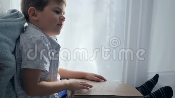 盲人学校可爱的孩子在房间的窗台上读盲文字体视频的预览图