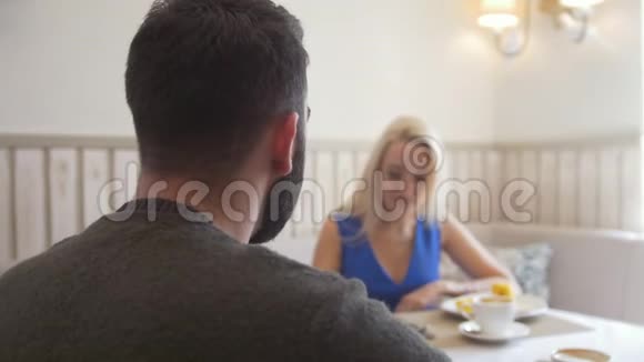 有魅力的年轻夫妇在咖啡厅边喝咖啡边聊天视频的预览图