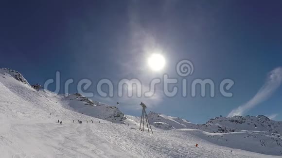 许多滑雪者在阳光下滑雪下山的山腰景色视频的预览图