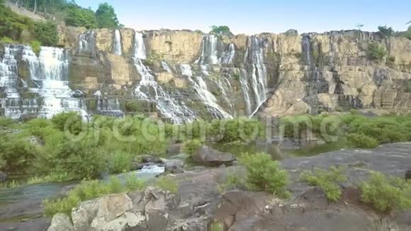 游客坐在灌木丛中观看Pongour瀑布视频的预览图