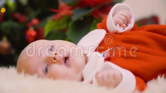 可爱的新生女孩在圣诞树的背景下睡着了视频的预览图