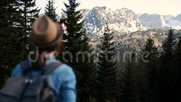 年轻的旅游妇女带着背包站在山顶上欣赏着令人惊叹的景色有魅力的女孩拍照片视频的预览图