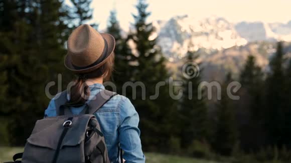 女游客带背包拍摄早晨景观年轻人和她一起拍了一张山景照片视频的预览图
