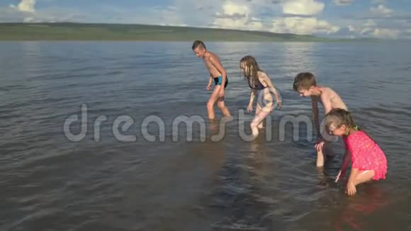 四个孩子沿着水跑视频的预览图