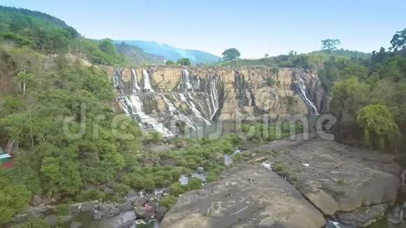 镜头从瀑布附近的石头上掠过游客视频的预览图