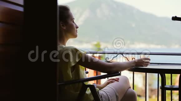 女游客饮用玻璃中的淡水穿黄色衬衫的年轻旅行者在放松的同时享受令人惊叹的风景视频的预览图