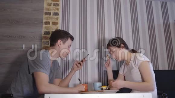 男人拿着电话女人在餐桌上吃饭视频的预览图