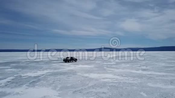 在冬季景观中驾驶汽车的无人机空中景观和高速驾驶过冰冻的湖泊视频的预览图