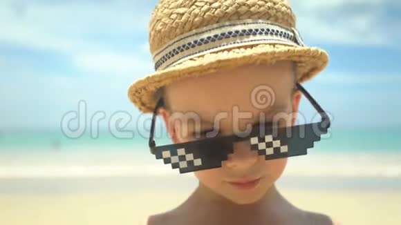 夏天海滩上戴着带太阳镜的草帽可爱小男孩的肖像视频的预览图