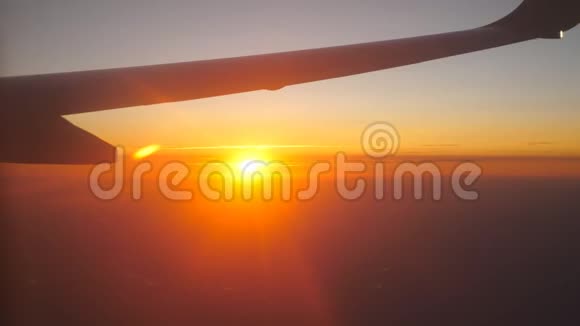 从飞机窗口到美丽的日出或日落天空中的飞机和云翼旅行概念关门视频的预览图