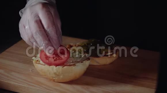 厨师准备汉堡在烤架上烤架上放入番茄片视频的预览图