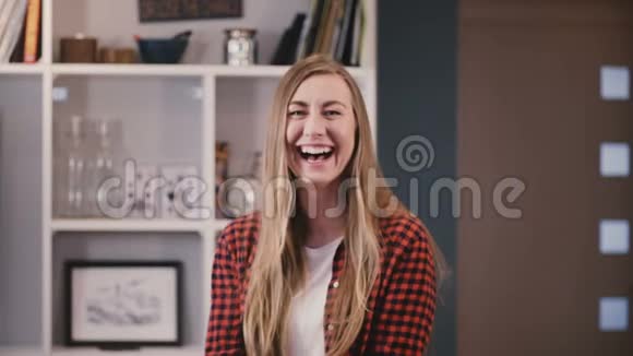 在镜头前摆姿势的白人女孩美丽的金发美女留着长发在家开心地笑着4K视频的预览图