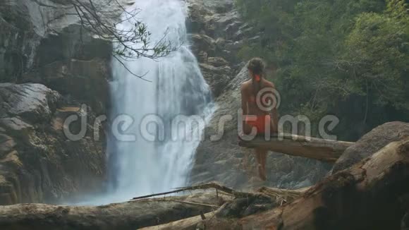 苗条的女孩在峡谷和瀑布上空降落视频的预览图