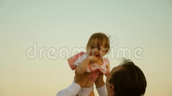 父亲把孩子扔得很高爸爸把女儿抛在天空中快乐的童年孩子和父母在一起a的概念视频的预览图