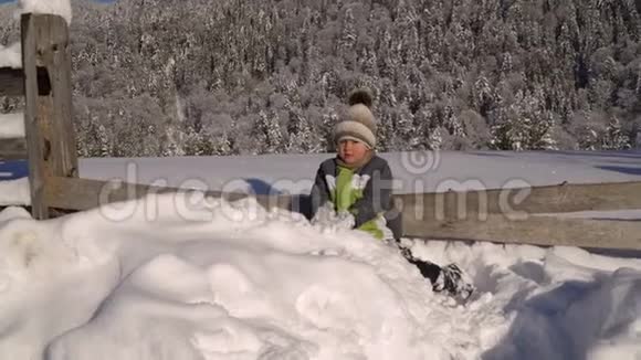 冬天小可爱的男孩在外面的雪地里玩耍背景是一片雪林这个男孩很高兴视频的预览图