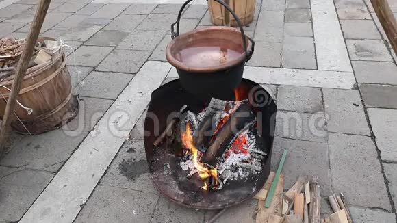 古老的铜锅有温水和原木制成的火视频的预览图