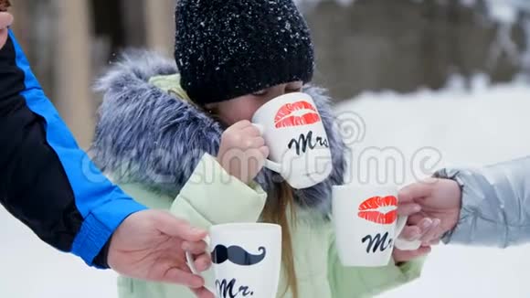 在冬林的背景下一个七岁的女孩从一个杯子里喝茶杯子上画着海绵视频的预览图