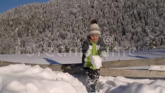 冬天小可爱的男孩在外面的雪地里玩耍背景是一片雪林这个男孩很高兴视频的预览图