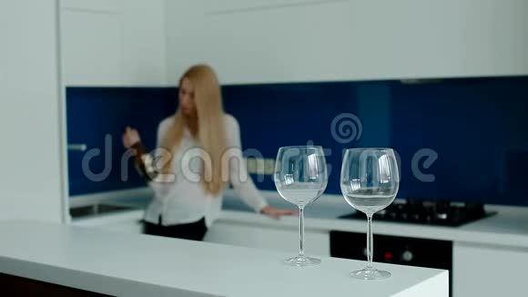 沮丧的女人在厨房里喝酒视频的预览图