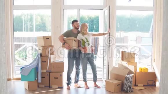 快乐的一对夫妇搬着纸板箱来到新家视频的预览图
