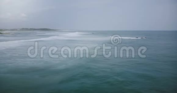 无人机照相机跟随巨浪到达异国情调的热带海岸与白色泡沫戏剧性的海滨天空碰撞视频的预览图