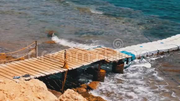 埃及红海沿岸的珊瑚礁上的海滩上的码头或浮桥视频的预览图