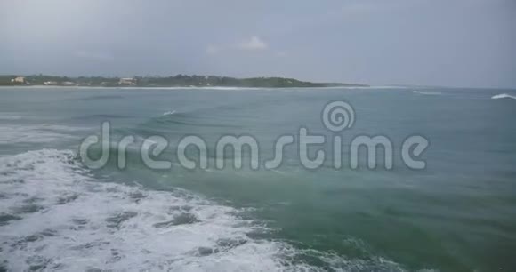 无人机照相机左转跟随巨大的海浪到达宁静的热带海滩并与美丽的泡沫碰撞视频的预览图