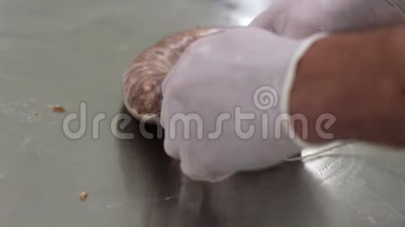 工人把肉装在贝壳里用网把它绑起来香肠制作工艺视频的预览图