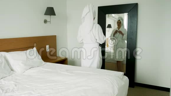 女孩穿着浴袍站在镜子前视频的预览图