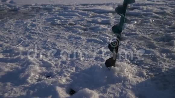 在冰湖钻洞进行冬季捕鱼快关门4K视频的预览图