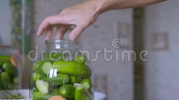 一个女人检查一个装满黄瓜的玻璃瓶做菜视频的预览图