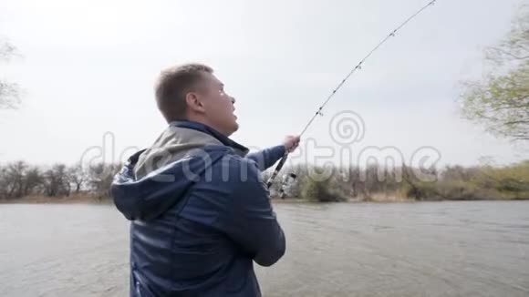 渔人在河底水上钓鱼旋转鱼卷视频的预览图