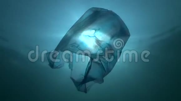 塑料污染用蓝色塑料袋在阳光下慢慢漂流在水下低角度拍摄背光视频的预览图