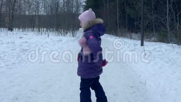 奔跑的少女少年在雪林中玩耍冬天走回头看慢动作视频的预览图