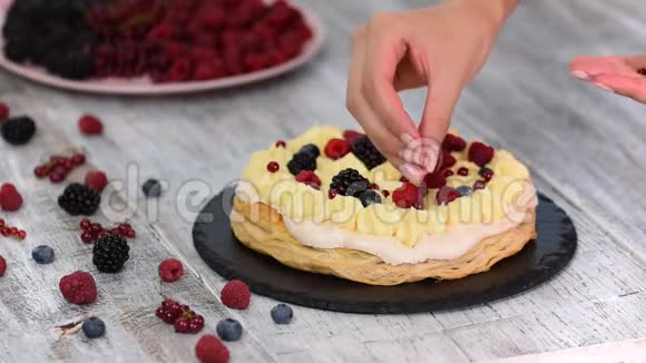 厨师用奶油冻和醋栗覆盆子黑莓蓝莓做泡芙糕点蛋糕美味的甜点视频的预览图