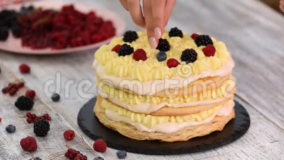 厨师用奶油冻和醋栗覆盆子黑莓蓝莓做泡芙糕点蛋糕美味的甜点视频的预览图