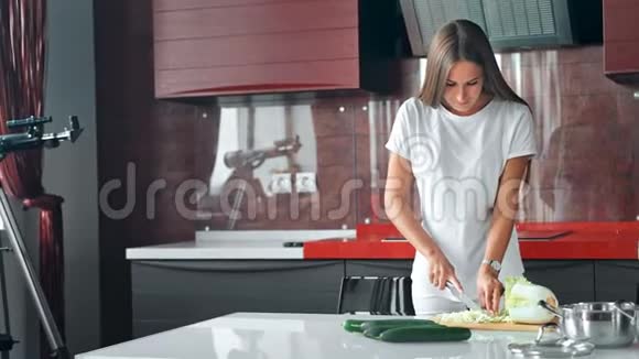 漂亮的年轻女人在厨房里切东西视频的预览图