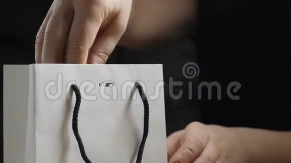 暗影浪漫的气氛快关门女性手指打开礼物用红色丝带弓拿着盒子取出视频的预览图