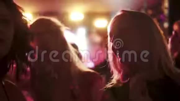 年轻女孩在舞蹈俱乐部的音乐会上和朋友们跳舞视频的预览图