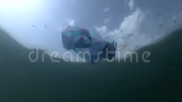 塑料污染用过的蓝色袋子和沙堆在水面下游泳背景是蓝天白云视频的预览图