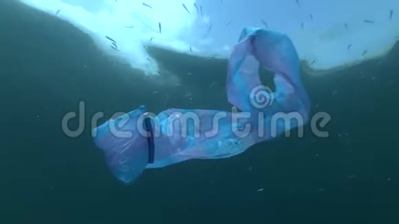 塑料污染用蓝色塑料袋和学校的鱼砂冶炼在水下游泳背景蓝天上有云视频的预览图