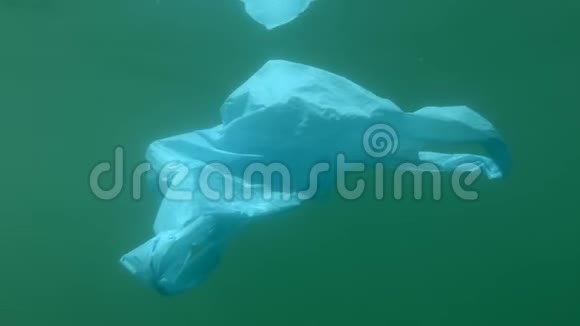 塑料污染一个废弃的蓝色塑料袋漂浮在绿色的水中视频的预览图