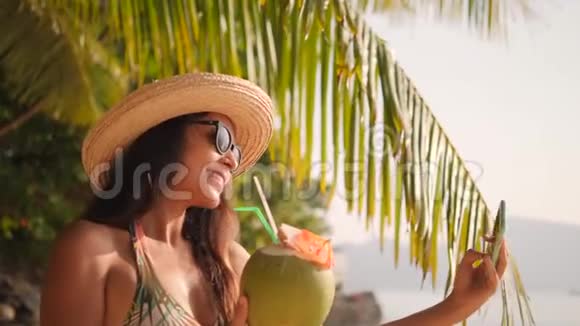 热带天堂岛海滩上使用手机制作自拍照片的年轻女性4K慢动作泰国普吉岛视频的预览图