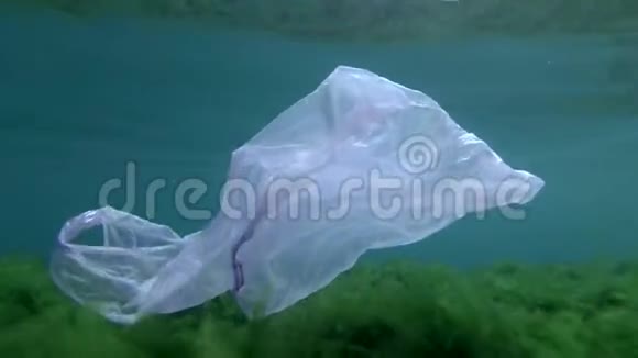 塑料污染用蓝色塑料袋漂浮在绿藻与地表之间的浅水中视频的预览图