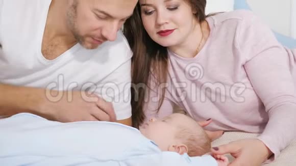 迷人的男人和女人在卧室里看着甜蜜的熟睡的婴儿视频的预览图