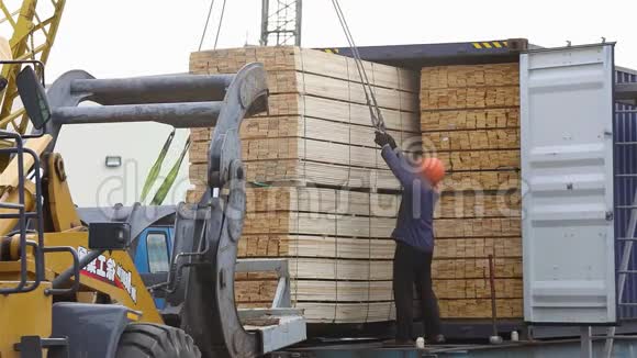男人把一根木梁装进车里用起重机把货物装进车里视频的预览图