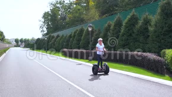 在一条安静的街道上骑着电动个人运输车的女人视频的预览图