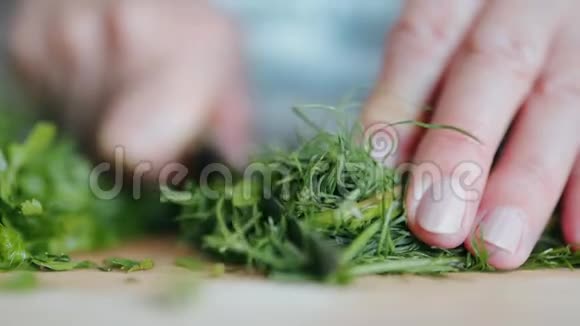 女人在厨房的桌子上切一片新鲜的绿色关闭慢动作视频的预览图