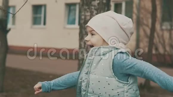 快乐的小女孩慢吞吞地跑在城市广场上视频的预览图